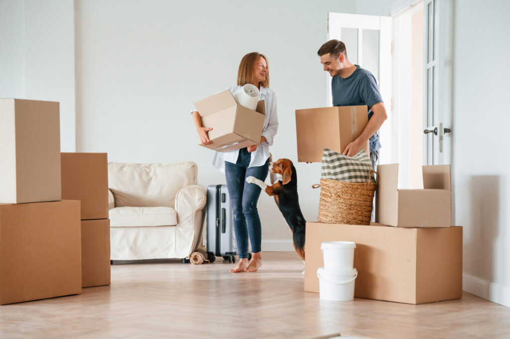 Family carrying moving boxes into their new home