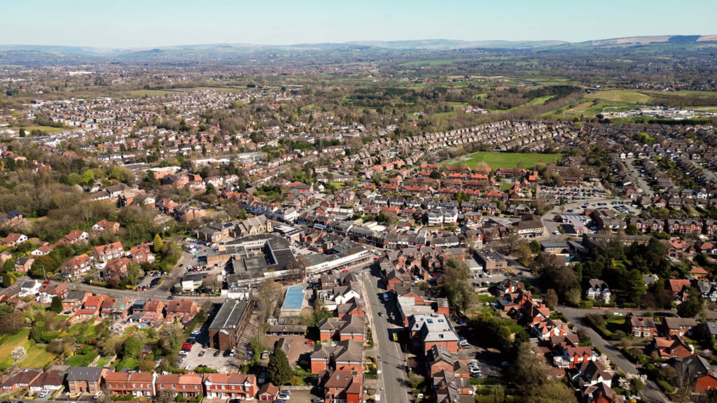 Aerial drone view over Bramhall rooftops and tree lined streets