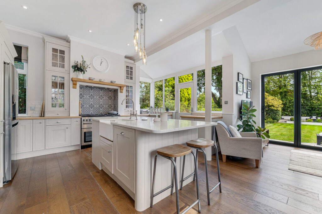 Open plan kitchen with island, bar stools and garden doors at 184 Bramhall Lane South, Bramhall